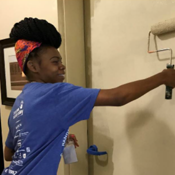 black woman using paint roller brush