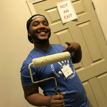 black man holding a paint roller brush