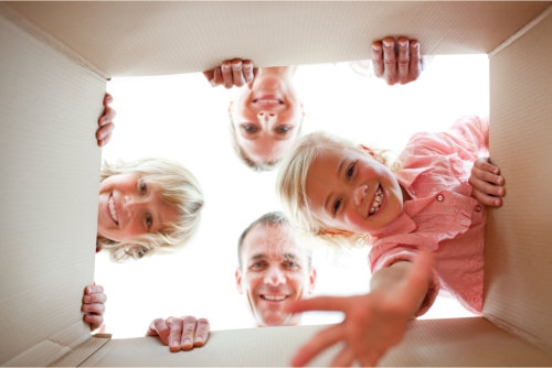 a family looking down happily at something inside the box